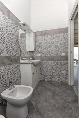 a bathroom with a toilet and a sink and a mirror at Casa negli Ulivi in Tremosine Sul Garda