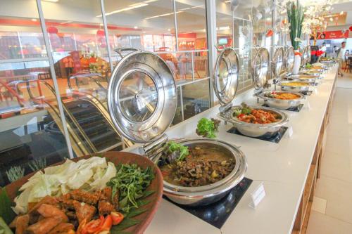 a buffet line with many different dishes of food at HARRIS Hotel Pontianak in Pontianak