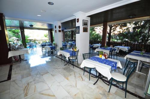 un restaurante con mesas y sillas azules y blancas en Navy Hotel, en Marmaris
