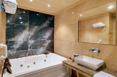 y baño con bañera y lavamanos. en The Orchard Greens Resort - A Centrally Heated Property, en Manali