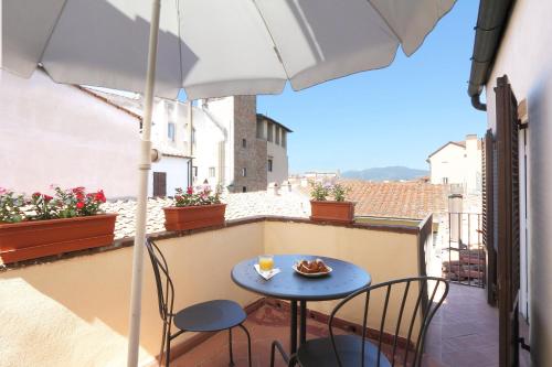 una mesa pequeña y sillas en un balcón con sombrilla en Hotel Bavaria, en Florencia