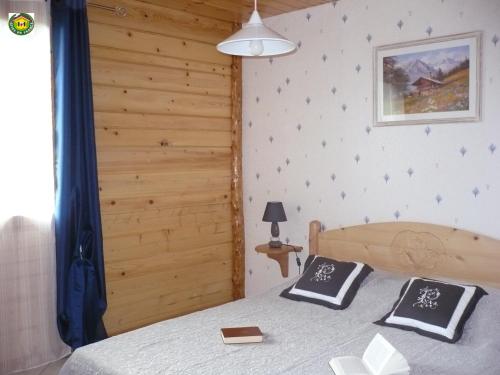 - une chambre avec un lit et 2 oreillers noirs et blancs dans l'établissement Gîte Les Sauvasses, à Puy-Sanières