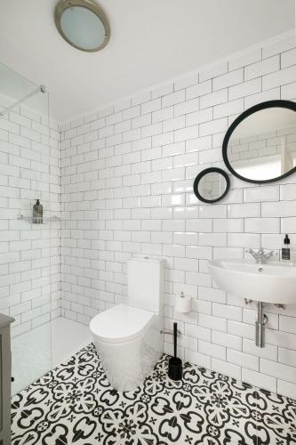 a white bathroom with a toilet and a sink at Almoura Giraldo Centro Histórico in Évora
