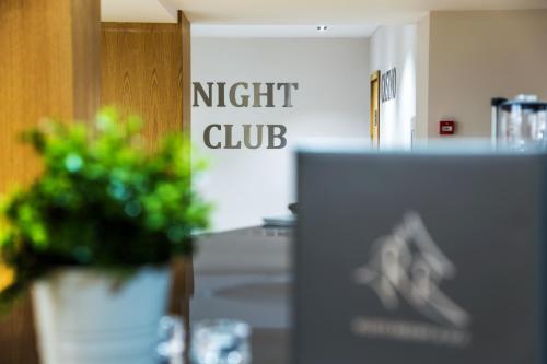 een uithangbord voor een nachtclub met een plant bij Rilets Resort & Spa in Rilski Manastir