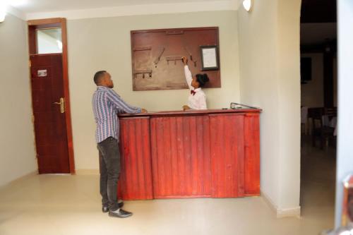 a man standing at a counter with his hand in the air at Obelisk Hotel Axum in Āksum
