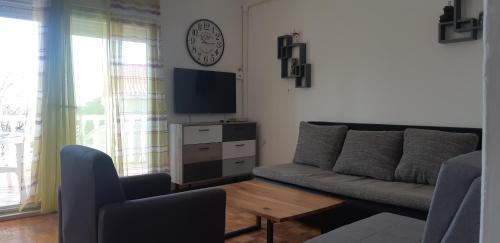 een woonkamer met een bank en een tv bij Apartmants Katica in Novalja