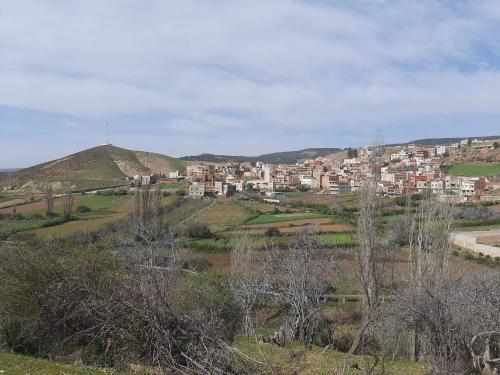 a city on top of a hill with houses at Le Gite du Barrage in Zaouia Ben Smine