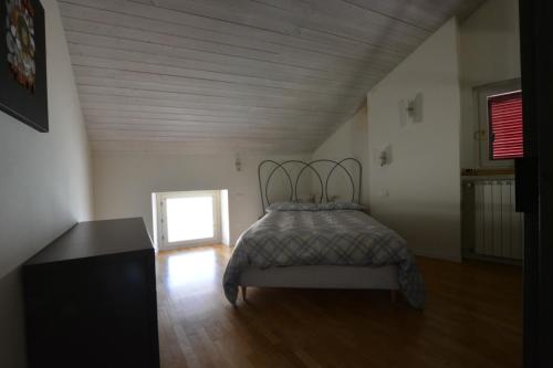 1 dormitorio con 1 cama y suelo de madera en La mia mansarda, en Biella