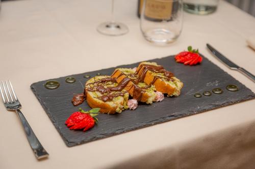 a black plate of food with strawberries on a table at Hotel Gran Roc in Sestriere