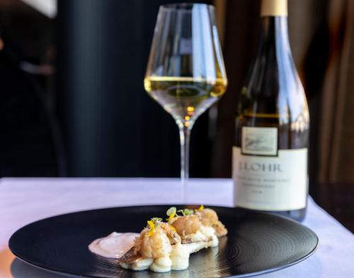 a plate of food next to a bottle of wine at Carbon Hotel in Genk