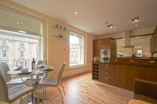 a kitchen and dining room with a table and chairs at 93a Grey Street Apartments in Newcastle upon Tyne