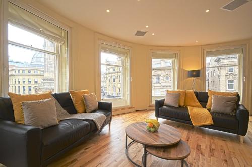 a living room with two couches and a table at 93a Grey Street Apartments in Newcastle upon Tyne