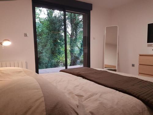 a bedroom with a bed with a large window at Le Domaine de Wail - Legends Resort in Wail