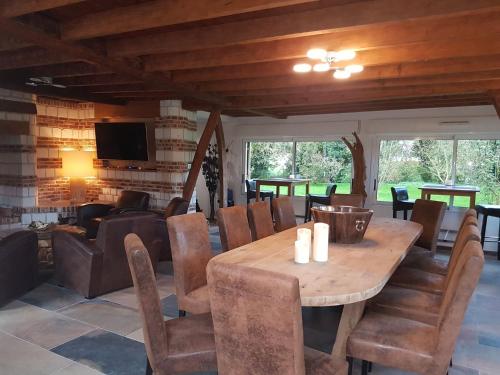ein Esszimmer mit einem Holztisch und Stühlen in der Unterkunft Le Domaine de Wail - Legends Resort in Wail