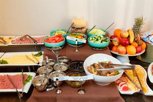 a table topped with bowls of food and wine glasses at Garden Park Inn in Almaty