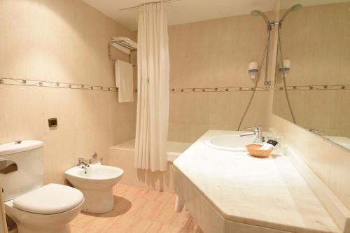 La salle de bains blanche est pourvue de toilettes et d'un lavabo. dans l'établissement RVHotels Tuca, à Vielha e Mijaran