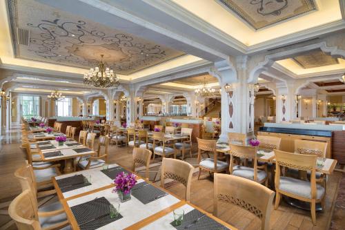 a restaurant with tables and chairs and a bar at Crowne Plaza Ocean Spring Resort, an IHG Hotel in Jimo