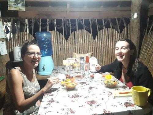 two women sitting at a table eating food at LHOYJEAN Garden Hostel in Batuan