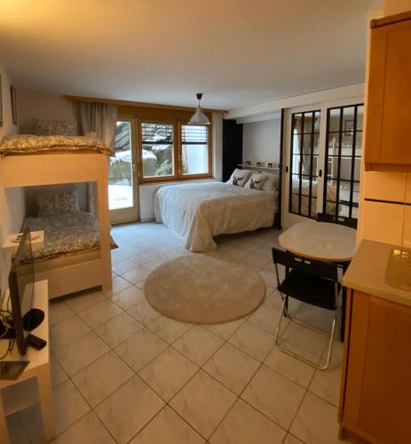 a bedroom with a bed and a desk and a table at Studio Brunnmatt in Zermatt