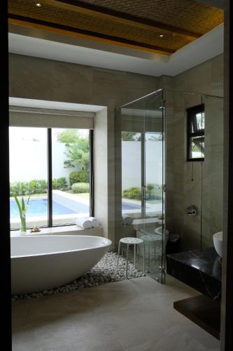 a bathroom with a tub and a glass shower at Kandaya Resort in Daanbantayan