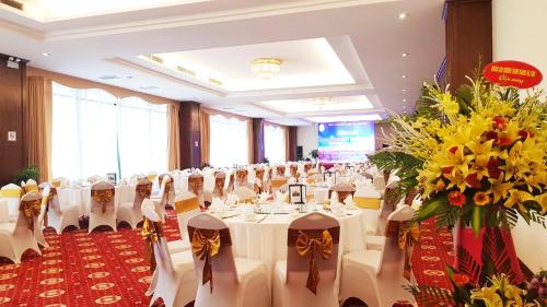 a banquet hall with white tables and chairs and flowers at Muong Thanh Grand Ha Tinh Hotel in Kỳ Anh