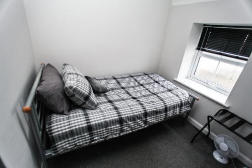 a small bedroom with a bed and a window at 4a Smart Apartments in Newark-on-Trent