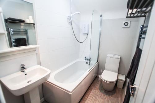 ein Badezimmer mit einem Waschbecken, einer Badewanne und einem WC in der Unterkunft 4a Smart Apartments in Newark upon Trent