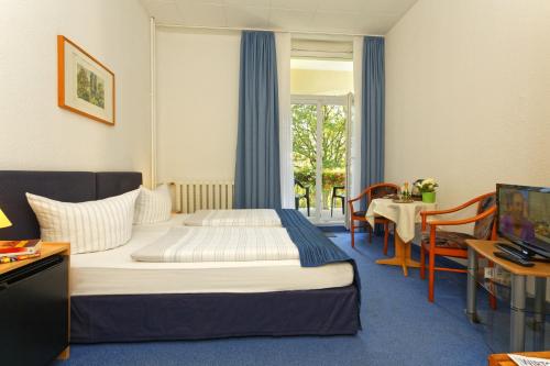 a hotel room with a bed and a table at Waldschloss Parow in Koserow