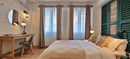 a bedroom with a bed and a desk and a table at Ananya Apartments Phase 2 in Kathmandu