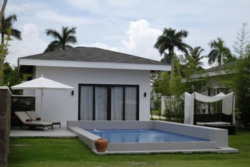 a white house with a swimming pool in the yard at Kandaya Resort in Daanbantayan