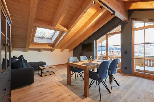 a living room with a table and chairs and a couch at Landhaus Herzogsteig in Krün