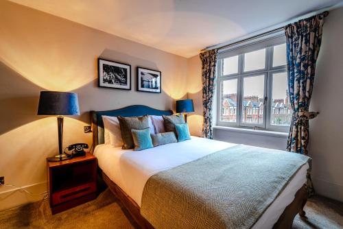 a bedroom with a large bed and a window at Aragon House in London