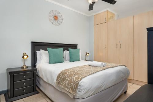 a bedroom with a large bed with green pillows at Four Seasons Apartments in Cape Town