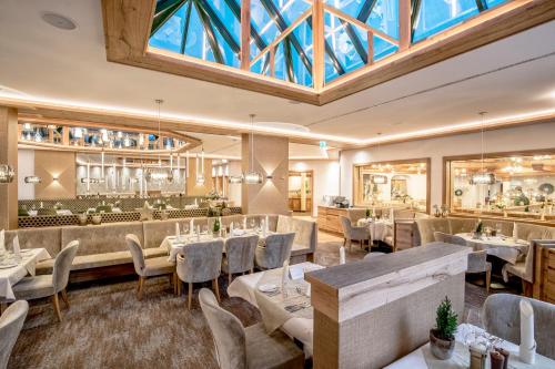 a restaurant with tables and chairs and a large skylight at Der Lärchenhof in Erpfendorf