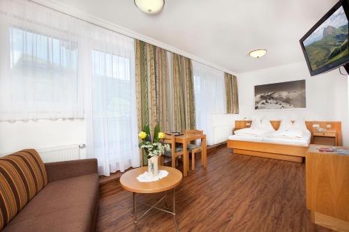 a living room with a couch and a table at Hotel Grundlhof in Bramberg am Wildkogel