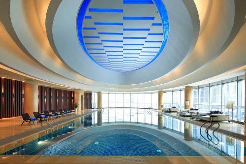 uma grande piscina num edifício com um tecto grande em Crowne Plaza Wuxi Taihu, an IHG Hotel em Wuxi
