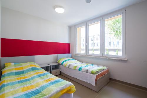 a bedroom with two beds and a window at Dom Studenta AŁ in Łomża
