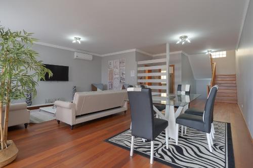 a dining room with a glass table and chairs at Charming Villa in Funchal in Funchal