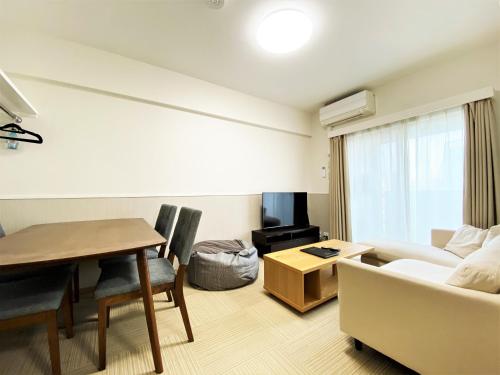 a living room with a table and a couch at Randor Hotel Fukuoka in Fukuoka