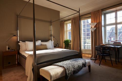 a bedroom with a four poster bed and a desk at Ett Hem in Stockholm