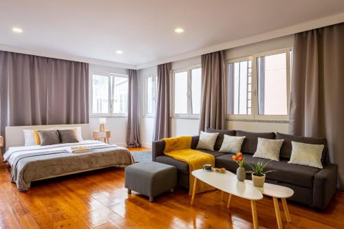 un soggiorno con divano e letto di Hola Lisbon Suites a Lisbona