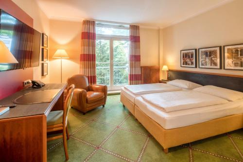 ゲルゼンキルヒェンにあるHotel Buerer Hofのベッドとデスクが備わるホテルルームです。