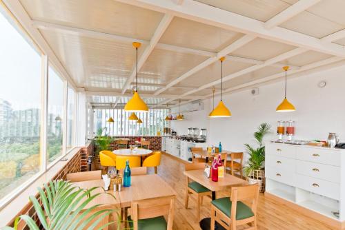 a restaurant with wooden tables and yellow chairs at bloomrooms @ City Centre in Bangalore