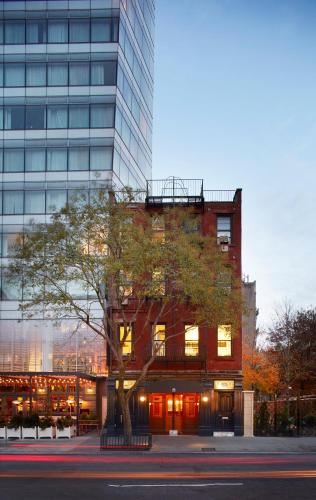 a building with a tree in front of a building at The Standard - East Village in New York