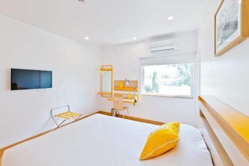 a white room with a bed and a window at bloomrooms @ City Centre in Bangalore