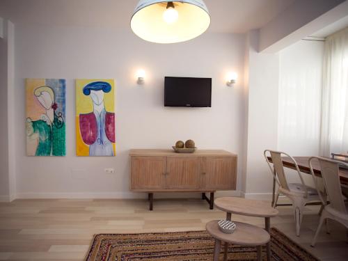 a living room with a television and a table and chairs at Malagaflat Soho in Málaga