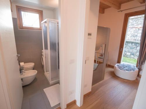 een badkamer met een douche, een toilet en een wastafel bij beautiful poolside and stunning lake view Gardenia in Bellano