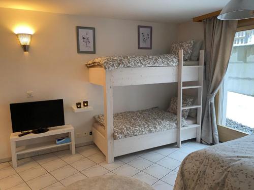 a bedroom with two bunk beds and a flat screen tv at Studio Brunnmatt in Zermatt