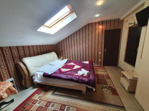 a small bedroom with a bed and a skylight at Apartment Studio on Bucuresti 9/1 in Chişinău