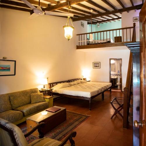 a living room with a bed and a couch at Presa di Goa - Managed by Smith and Appy in Calangute